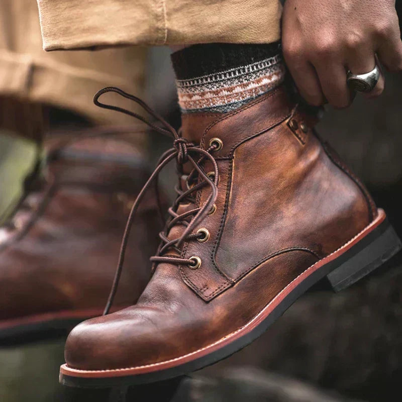 Brown lace-up ankle boot being laced up, worn with jeans