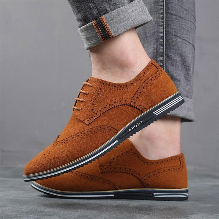 Black wingtip brogues worn with cuffed jeans