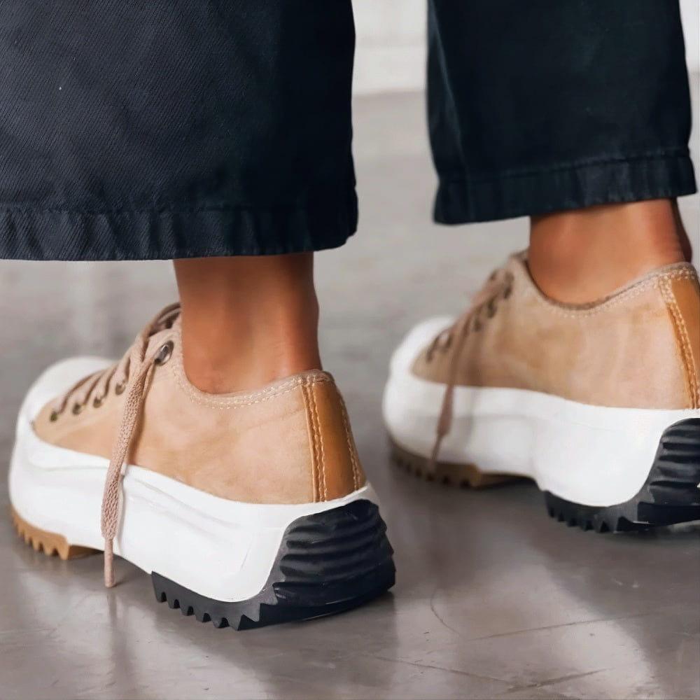 Tan platform sneakers worn with cropped trousers